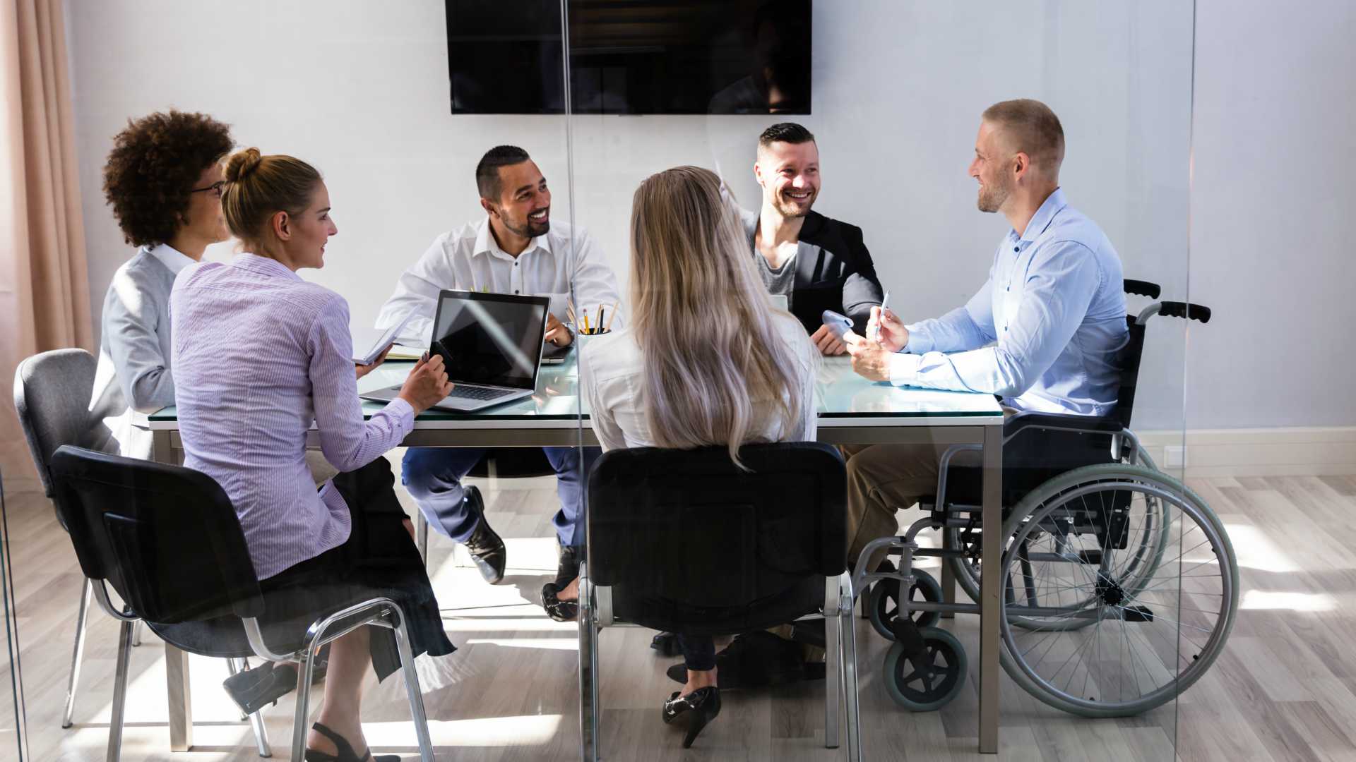 A diverse team meeting that includes a colleague using a wheelchair