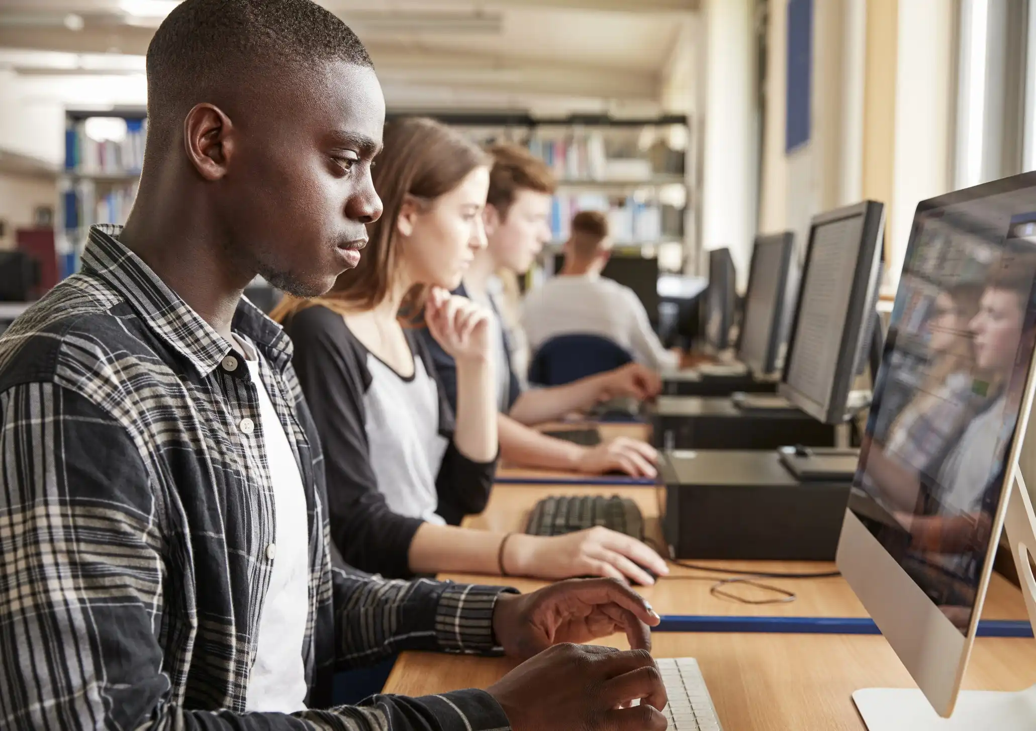 Students of varied backgrounds learning side-by-side at a computer lab