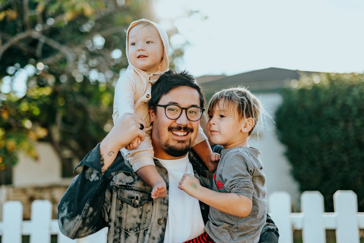 A father with two young children in a warm, everyday moment