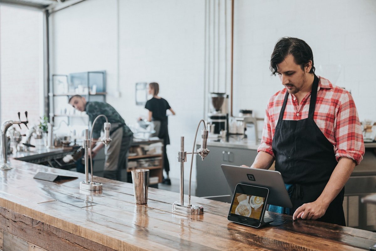 A young business owner working at the counter of a small cafe